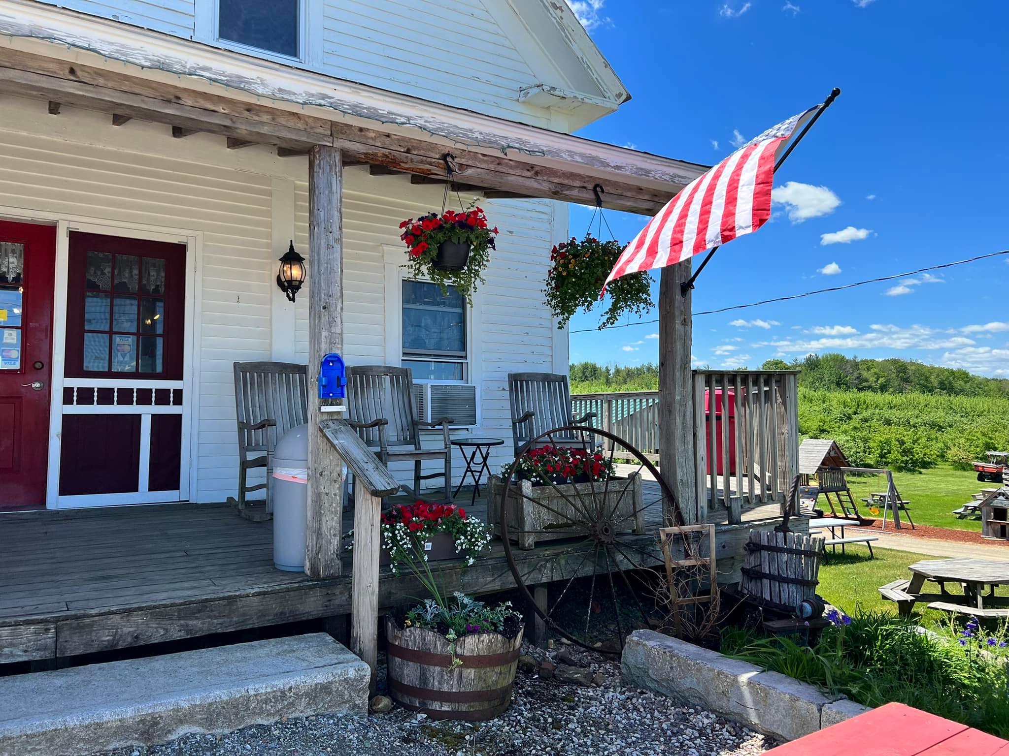 Appleview’s country store porch with red doors, rocking chairs, and orchard views